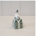 Green Santa sitting on LED Present